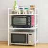 A white shelving unit with two microwaves and various kitchen containers on the top shelf, set against a tiled wall. Anteprima dell’immagine prodotto