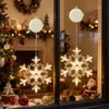 Christmas decorations in a window, including two illuminated snowflake lights. Anteprima dell’immagine prodotto
