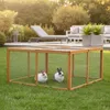 Two rabbits are in a wooden outdoor enclosure on a grassy lawn, with patio furniture and plants in the background. Náhľad obrázku produktu