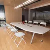 A modern conference room with a long white table and white chairs. Podgląd zdjęcia produktu
