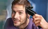 A man is using a hair clipper on his head. Anteprima dell’immagine prodotto