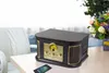 A retro-style multifunctional record player is placed on a table next to a sofa and a bouquet of flowers. Produktbild-Vorschau