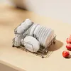 A dish rack filled with white plates and cups on a wooden countertop. Produktbild-Vorschau