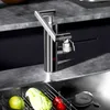 A modern kitchen sink area with a faucet and fresh produce in a drying rack. Produktbild-Vorschau