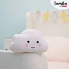 A cute cloud-shaped night light sits on a white surface in front of a blurred background of a child's room. Voir les images du produit