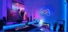 A gaming setup with multiple monitors, a keyboard, and decorative neon lights. Produktbild-Vorschau