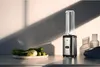 A WMF Kult X Mix & Go Mini Smoothie Maker is shown on a kitchen counter with a plate of vegetables. Produktbild-Vorschau