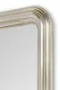 A close-up of the corner of a mirror frame. Voir les images du produit