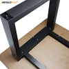 Close-up view of a black metal table leg frame being attached to a wooden tabletop with screws. Anteprima dell’immagine prodotto