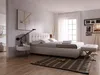 A modern bedroom with a bed, nightstand, and artwork. Náhled obrázku produktu