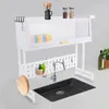 A white dish rack is set up over a black sink, with various kitchen items like plates, bottles, and utensils displayed. Podgląd zdjęcia produktu