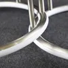 A close-up view of two interlocking rings with a brushed metal finish and a white inner surface, resting on a dark gray textured surface. Podgląd zdjęcia produktu
