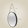 A round mirror with a rope hanger, with dimensions indicated by lines and text. Produktbild-Vorschau