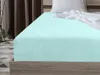 A close-up view of a mint green fitted sheet on a bed. Náhled obrázku produktu