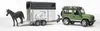 A toy Land Rover Defender towing a horse trailer with a toy horse on the ramp. Produktbild-Vorschau