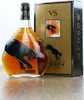 A bottle of Meukow VS Cognac and its gift box are displayed on a wooden surface. Produktbild-Vorschau