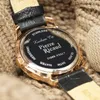 Close-up of the back of a watch with a leather strap, resting on a knitted fabric. Produktbild-Vorschau