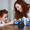 A mother and child are opening gifts, with a Bluetooth speaker in the foreground. Produktbild-Vorschau