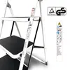 A close-up view of a white folding step stool with black anti-slip treads. Voir les images du produit