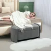 A woman is lying on a bed next to a storage bench. Anteprima dell’immagine prodotto