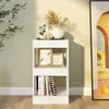A white bookshelf with decorative items and books on it, placed against a light green wall. Produktbild-Vorschau