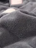 A close-up view of a soft, gray, fluffy fabric, possibly a towel or blanket, with hints of pink shapes visible in the background. Produktbild-Vorschau