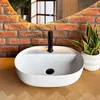 A modern bathroom sink with a black faucet, set against a brick wall and a wooden countertop. Náhled obrázku produktu