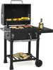 A black charcoal grill with food cooking on it, set against a white background. Podgląd zdjęcia produktu