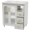 A white ceramic sink with a white cabinet underneath, featuring gold handles and fluted glass doors. Produktbild-Vorschau