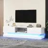 A modern white TV stand with LED lighting, featuring a television and decorative items. Produktbild-Vorschau