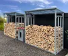Two metal firewood racks filled with logs, placed outdoors next to a dark fence. Produktbild-Vorschau