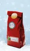 A red gift bag decorated with Christmas-themed stickers, sitting in snow with a light blue, snowflake-filled background. Náhľad obrázku produktu