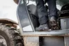A person is stepping into a construction vehicle. Produktbild-Vorschau