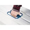 A hand wearing a plaid shirt is holding a blue tool on a silver corrugated surface. Anteprima dell’immagine prodotto
