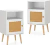 Two white nightstands with rattan cabinet doors and wooden legs are shown against a white background. Náhled obrázku produktu