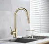 A gold kitchen faucet is shown in use over a sink. Produktbild-Vorschau