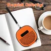 An orange protective case for a speaker is placed on an open notebook next to a cup of coffee and glasses. Produktbild-Vorschau