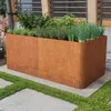 A corten steel raised garden bed filled with various herbs and plants, set on a concrete patio with grass accents. Produktbild-Vorschau