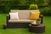 A garden sofa with cushions and a coffee table on a lawn. Podgląd zdjęcia produktu