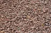 A close-up, overhead view of red granite gravel. Produktbild-Vorschau