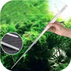 A hand holding a long pair of tweezers over aquatic plants in an aquarium. Podgląd zdjęcia produktu