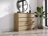 A dresser with eight drawers is shown in a room with a mirror and a plant. Náhľad obrázku produktu