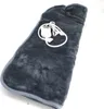 A dark gray electric heating pad with a white controller and cord, lying on a white surface. Produktbild-Vorschau