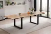 A dining table with a natural wood top and black metal legs, set in a well-lit room with a rug underneath and a window in the background. Produktbild-Vorschau