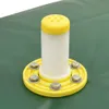 A close-up view of a white plastic pipe with a yellow cap, attached to a green surface with a yellow flange and bolts. Podgląd zdjęcia produktu