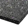 A close-up, angled view of a thick, black, textured rubber mat with colorful flecks embedded within it. The mat is shown on a white background. Náhled obrázku produktu