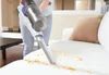 A person is using a white and purple cordless vacuum cleaner to clean up crumbs from a white sofa. Podgląd zdjęcia produktu