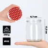 A hand holds a red and white polka dot lid above a clear glass jar, with measurement indicators and weight information displayed. Anteprima dell’immagine prodotto