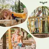 A collage of three images showing children playing on a wooden playground structure in a forest setting. One child looks through a telescope, another walks on a rope bridge, and a third plays in a sandbox. Produktbild-Vorschau