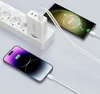 A white multi-port charger is plugged into a power strip, charging two smartphones. Produktbild-Vorschau